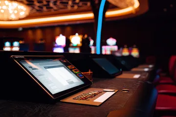 A man celebrating a winning moment on his laptop while gaming symbols float around him, capturing the excitement of 88FD games.